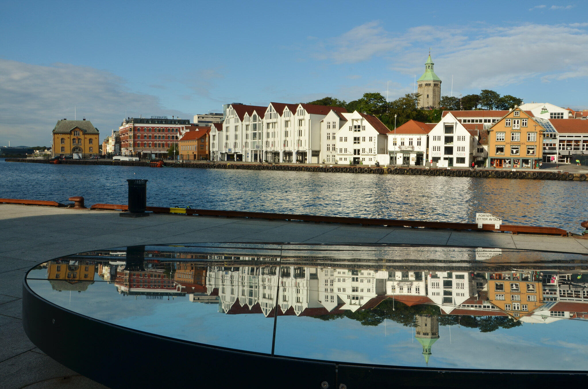 Husrekke i Stavanger speiler seg i en vanndam.