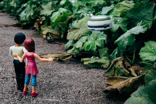Figurer av gutt og jente betrakter en robot.