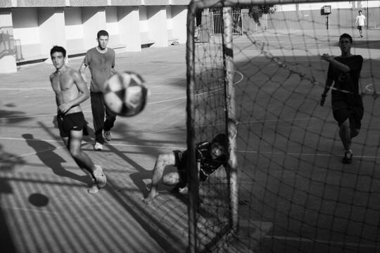 Illustrasjonsbilde i svart-hvitt av gutter som spiller gatefotball.